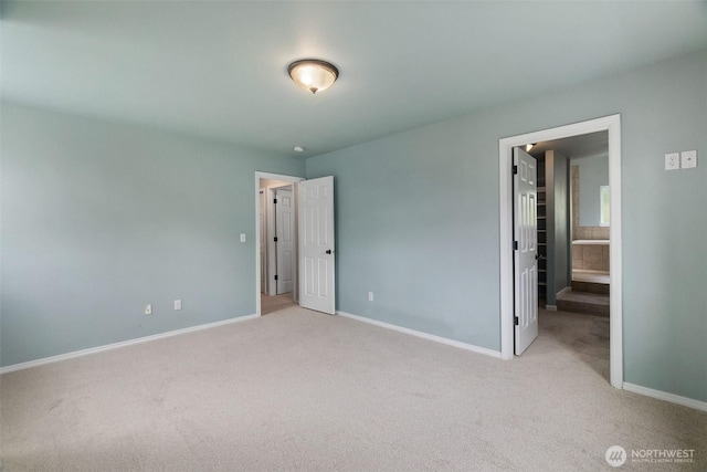 unfurnished bedroom with baseboards, carpet, and a spacious closet