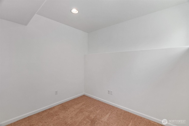 empty room featuring recessed lighting, baseboards, and light colored carpet
