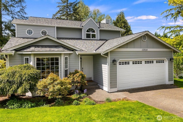 traditional home featuring a chimney, driveway, a shingled roof, and a garage