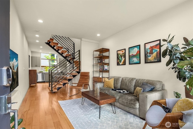 living area featuring recessed lighting, light wood-type flooring, and stairs