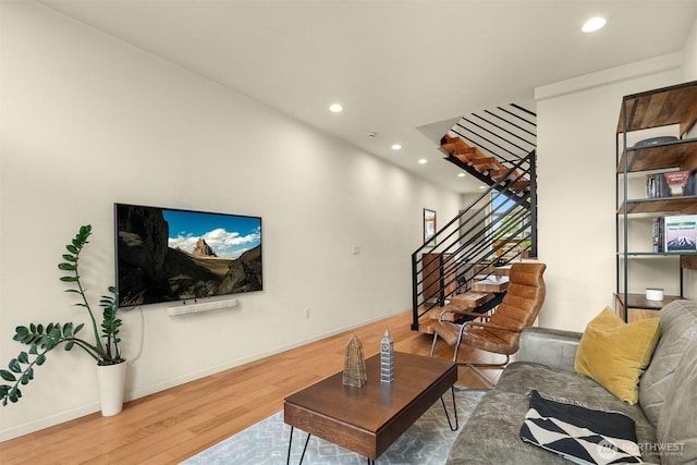living area featuring recessed lighting, baseboards, wood finished floors, and stairway