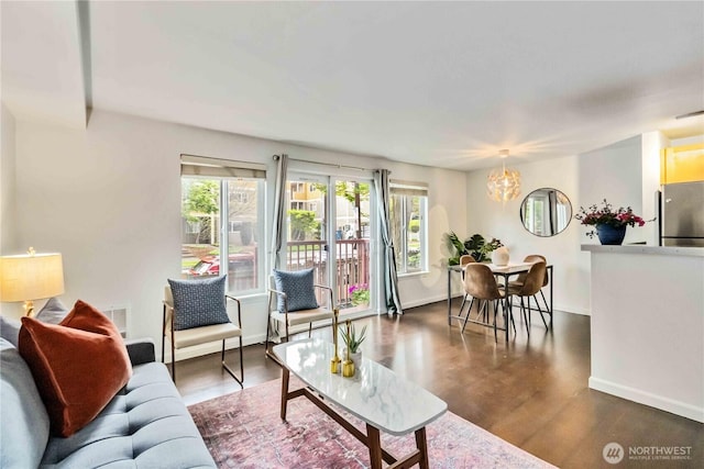 3661 Phinney Ave N Unit 208, Seattle, WA 98103 - living room featuring dark wood-style flooring, baseboards, an inviting chandelier, and visible vents