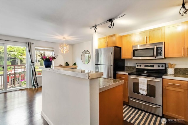 3661 Phinney Ave N Unit 208, Seattle, WA 98103 - kitchen featuring a kitchen island, dark wood-style floors, tile counters, rail lighting, and appliances with stainless steel finishes