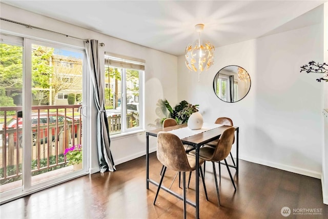 3661 Phinney Ave N Unit 208, Seattle, WA 98103 - dining room featuring an inviting chandelier, baseboards, and wood finished floors