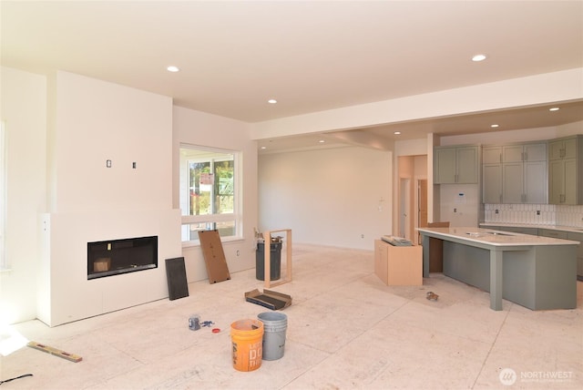 kitchen with decorative backsplash, a kitchen island, recessed lighting, light countertops, and gray cabinetry
