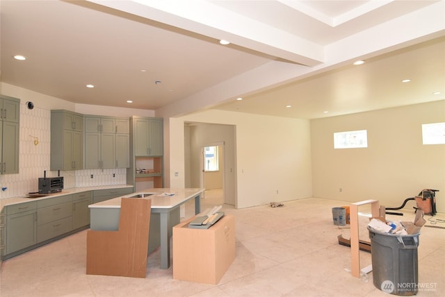 kitchen featuring backsplash, a center island, light countertops, green cabinets, and recessed lighting