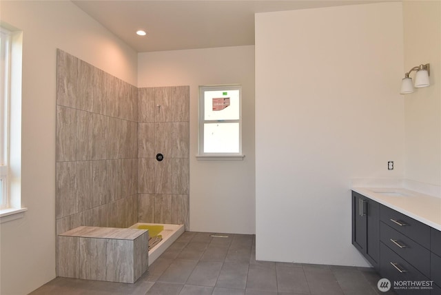 bathroom featuring tiled shower, tile patterned flooring, and vanity