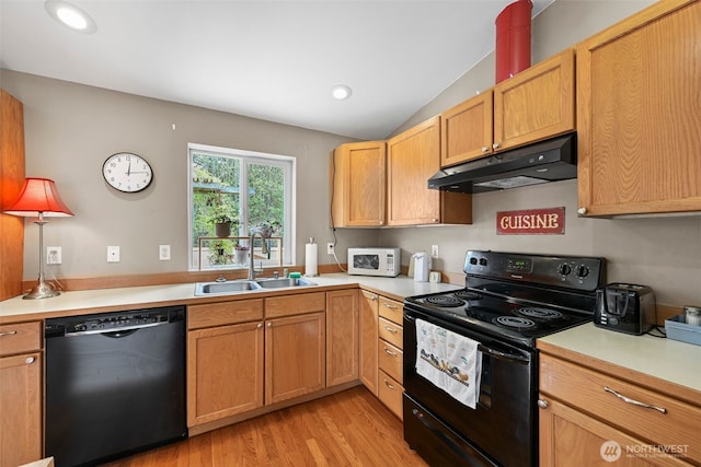 kitchen with a sink, light countertops, black appliances, and under cabinet range hood