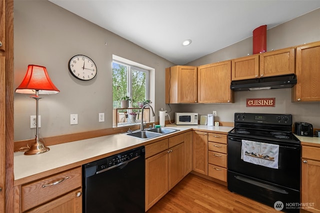 kitchen with light wood-type flooring, light countertops, under cabinet range hood, a sink, and black appliances
