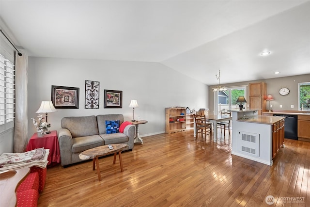 living room featuring recessed lighting, light wood-style flooring, vaulted ceiling, and an inviting chandelier