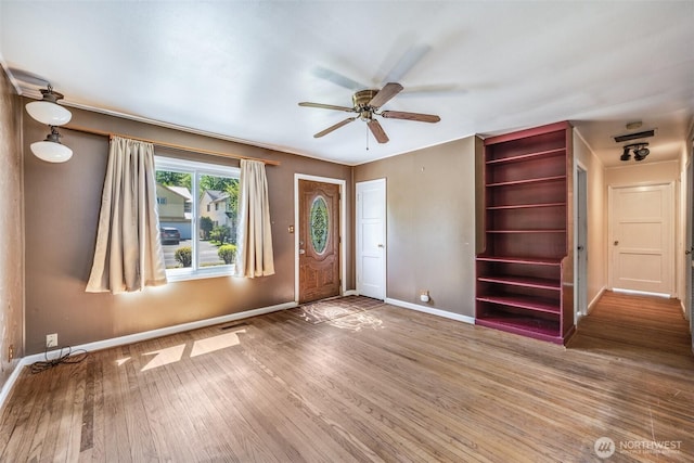 entryway featuring baseboards, ceiling fan, wood finished floors, and visible vents