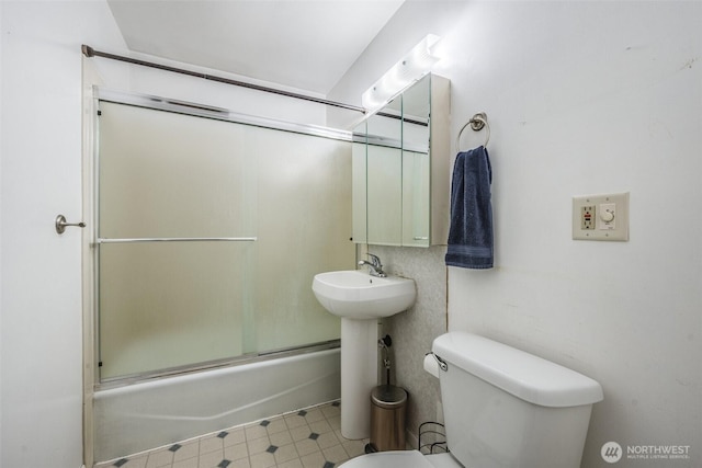 full bath with shower / bath combination with glass door and toilet