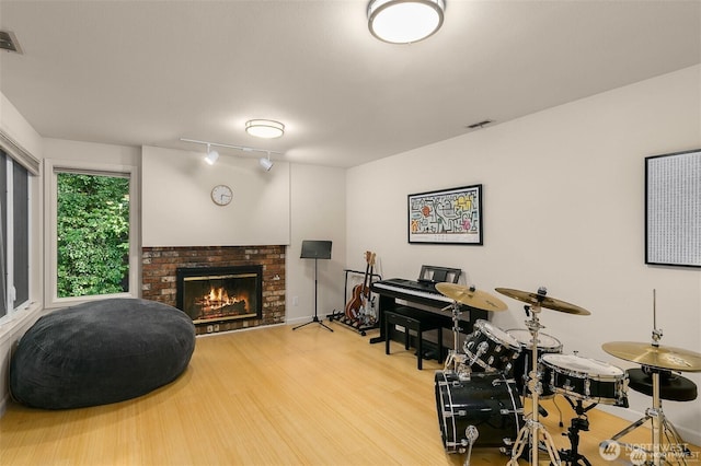 interior space with visible vents, track lighting, wood finished floors, and a fireplace