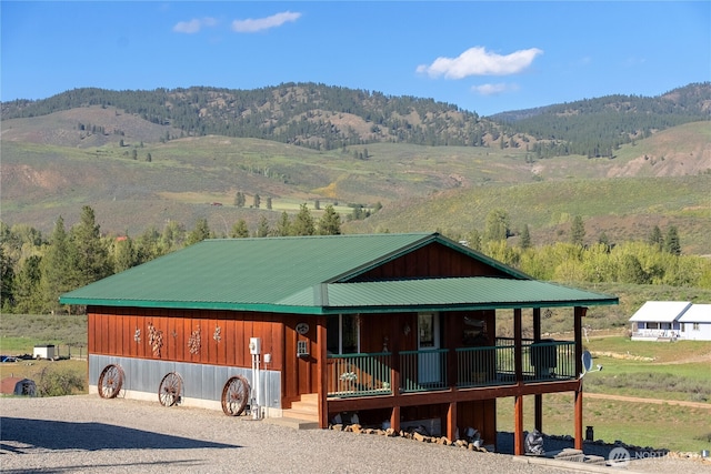 view of front of house featuring a porch, a mountain view, and metal roof