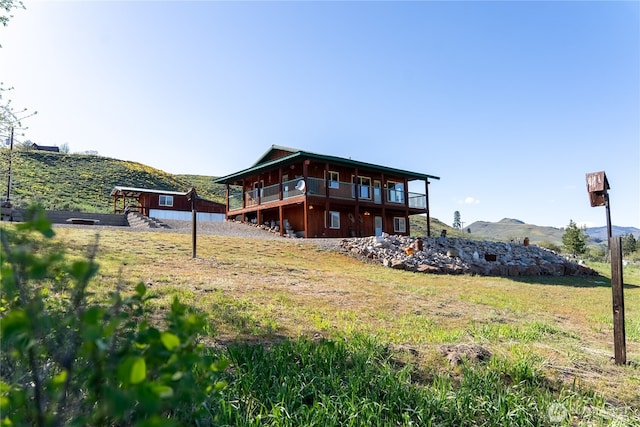 back of property with a deck with mountain view