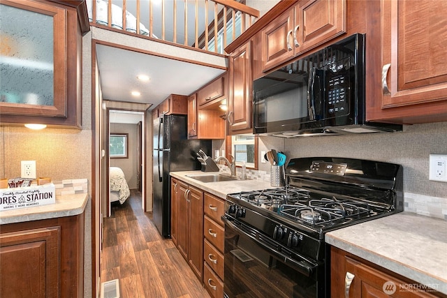 990 S Lake Whatcom Blvd Unit 9, Sedro Woolley, WA 98284 - kitchen featuring a sink, brown cabinetry, dark wood-type flooring, visible vents, and black appliances