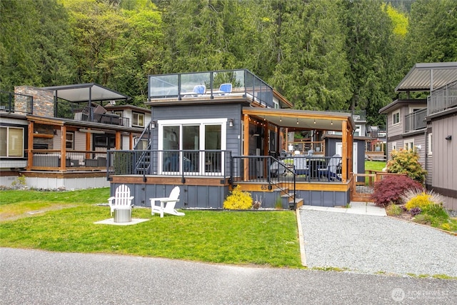 990 S Lake Whatcom Blvd Unit 65, Sedro Woolley, WA 98284 - rear view of house featuring a lawn, covered porch, and a forest view