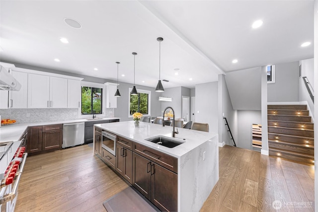 kitchen with a sink, appliances with stainless steel finishes, and light wood-type flooring