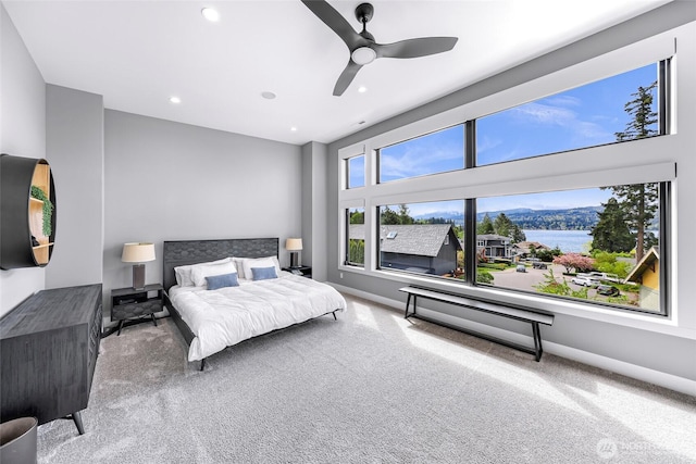 carpeted bedroom with recessed lighting, baseboards, ceiling fan, and a water view