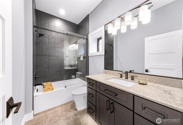 bathroom featuring toilet, combined bath / shower with glass door, and vanity