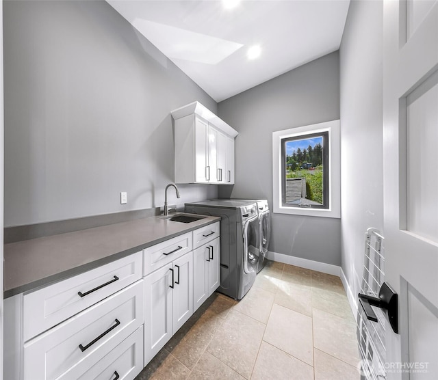 laundry area with a sink, baseboards, independent washer and dryer, and cabinet space