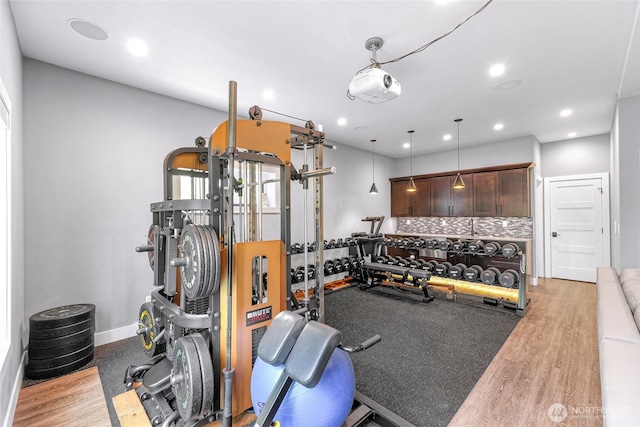 workout area with recessed lighting, baseboards, and wood finished floors
