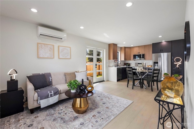 living room with light wood-style floors, recessed lighting, and a wall unit AC