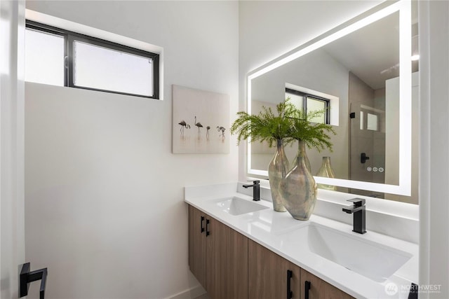 full bath with a sink, a stall shower, and double vanity