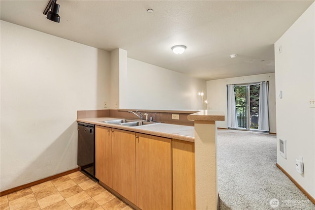 412 11th Ave, Seattle, WA 98122 - kitchen featuring a sink, dishwasher, a peninsula, light countertops, and baseboards