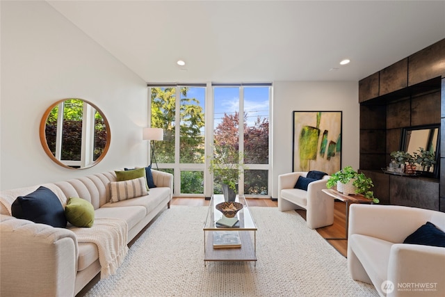 living room with recessed lighting, floor to ceiling windows, and wood finished floors