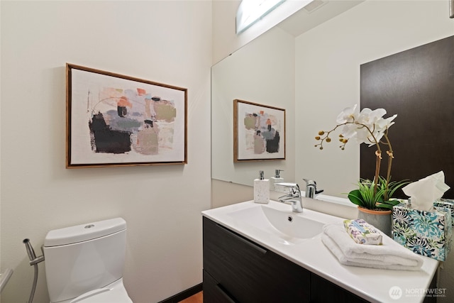 half bathroom with vanity and toilet