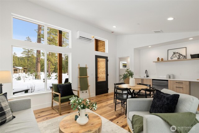 living room featuring indoor wet bar, recessed lighting, a wall mounted AC, and light wood-style floors