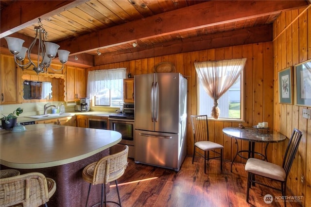 420W Lough Ln, Westport, WA 98595 - kitchen featuring beam ceiling, stainless steel appliances, wooden walls, dark wood-type flooring, and a chandelier