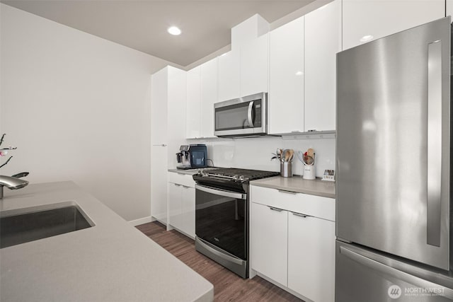 4818 Springside St, Bellingham, WA 98226 - kitchen featuring appliances with stainless steel finishes, light countertops, dark wood-style flooring, white cabinets, and recessed lighting