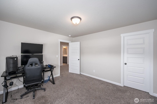 carpeted home office featuring baseboards