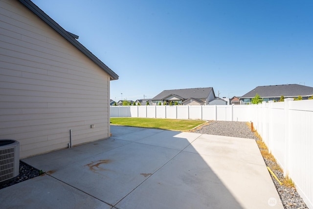 view of patio with a fenced backyard, central air condition unit, and a residential view