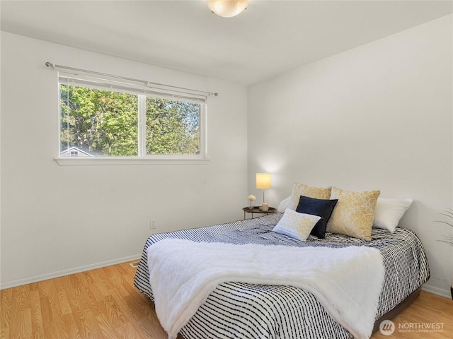 bedroom featuring baseboards and wood finished floors