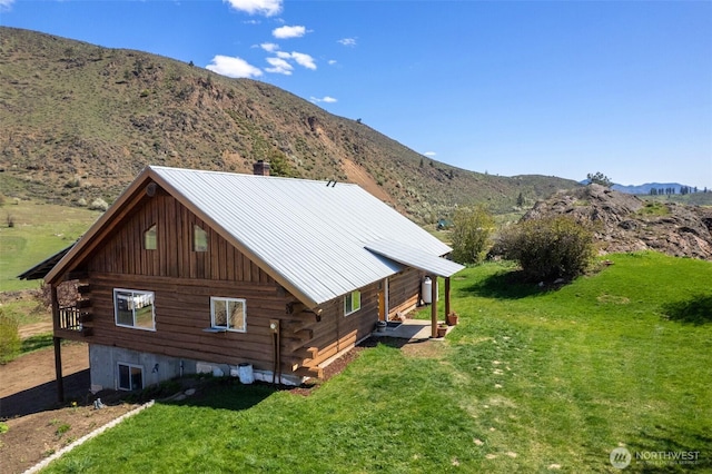 exterior space with log siding, a yard, and a mountain view