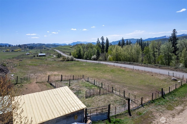 view of yard with a rural view, fence, a mountain view, and an enclosed area