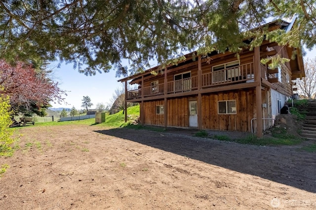 back of property with a wooden deck and board and batten siding