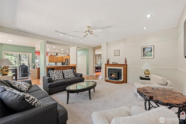 living area featuring recessed lighting, ceiling fan, track lighting, and light carpet