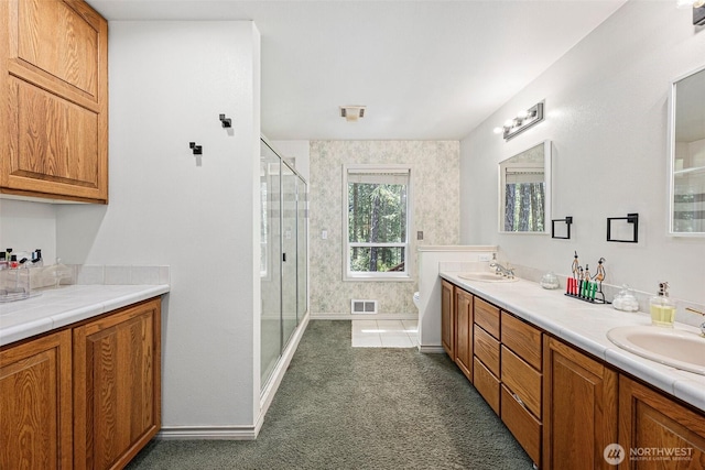 full bathroom with a sink, a stall shower, double vanity, and visible vents