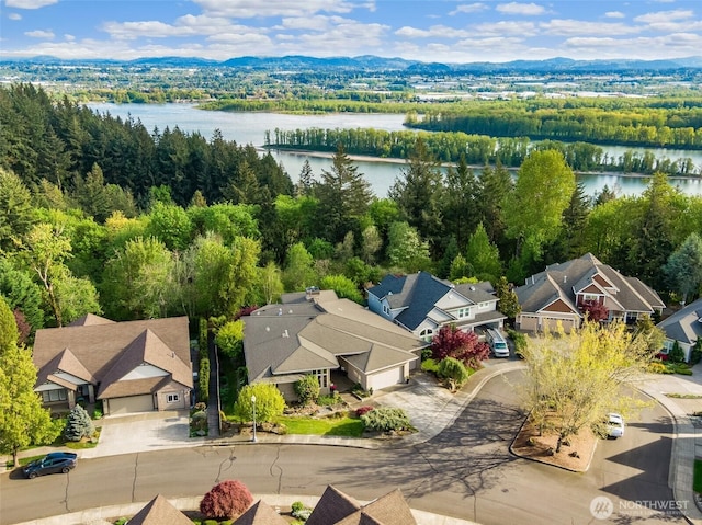 bird's eye view with a residential view, a water view, and a wooded view