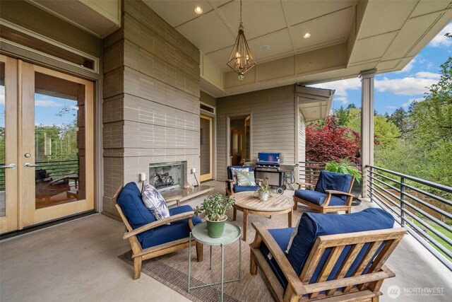 view of patio / terrace with area for grilling, a fireplace, and a balcony
