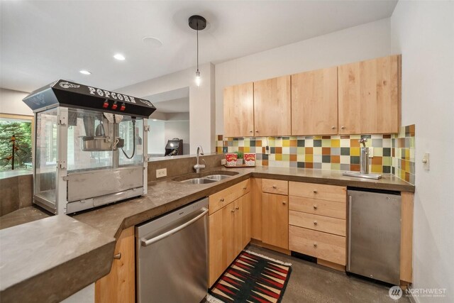 kitchen featuring light brown cabinetry, fridge, a sink, tasteful backsplash, and stainless steel dishwasher