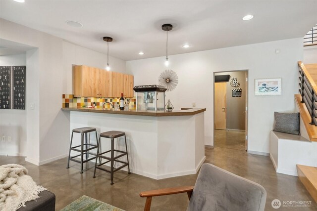 bar featuring recessed lighting, baseboards, and finished concrete flooring