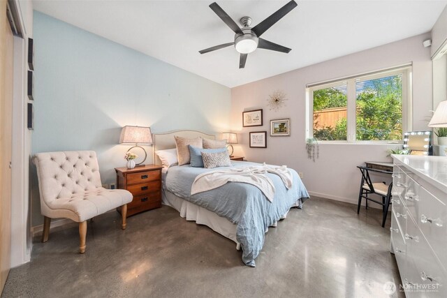 bedroom featuring concrete flooring, baseboards, and a ceiling fan