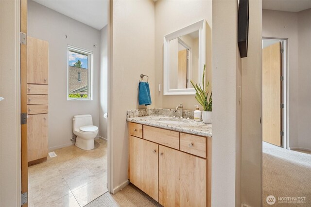 bathroom with toilet, baseboards, and vanity