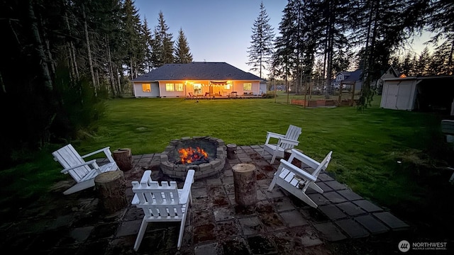 118 Woodview Ln, Napavine, WA 98596 - yard at dusk with a storage shed, a fire pit, an outdoor structure, and a patio area