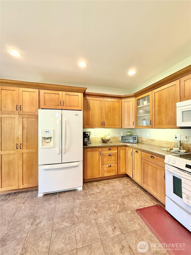 kitchen featuring recessed lighting, a toaster, white appliances, and glass insert cabinets